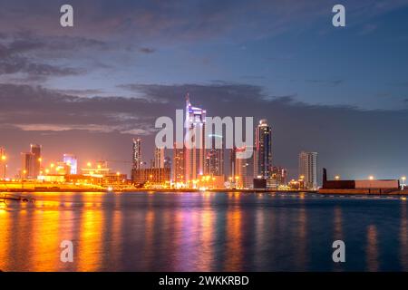 Manama, Bahrein - 27 dicembre 2023: Porto finanziario del Bahrain, Harbor Towers, vista dello skyline del Bahrain al tramonto all'alba Foto Stock