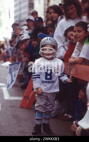 Dallas Texas USA, gennaio 1993: Young boy indossa un casco da football dei Dallas Cowboys e una maglia da football con il numero del suo giocatore preferito (il quarterback Troy Aikman) alla parata del centro per celebrare la vittoria della squadra NFL nel Super Bowl. ©Bob Daemmrich Foto Stock