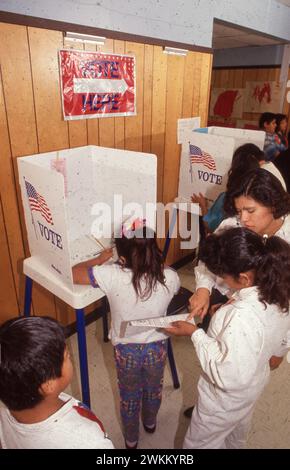 Austin Texas USA, circa 1994: Studenti di quinto grado che tengono le elezioni fittizie per il presidente completo di effettivi stand di voto e giudici elettorali. ©Bob Daemmrich Foto Stock