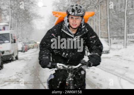 Corriere di biciclette in inverno, Monaco, Baviera, Germania Foto Stock