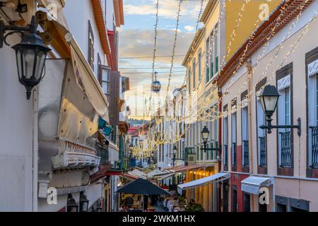 Una funivia passa sopra la famosa Rua de Santa Maria, stretta strada di caffetterie, porte colorate e negozi a Funchal, Portogallo, Isola di Madeira. Foto Stock