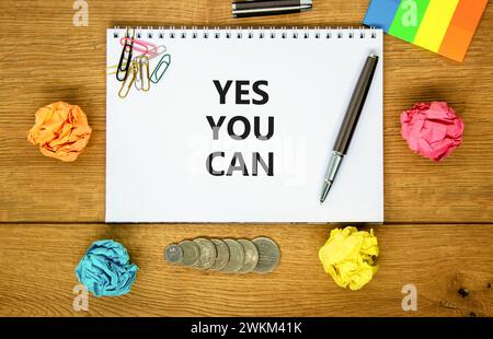 Motivazionale Sì puoi simbolo. Parole concettuali Sì che puoi su bella nota bianca. Splendido sfondo in legno. Penna nera. Carta colorata. Business mo Foto Stock