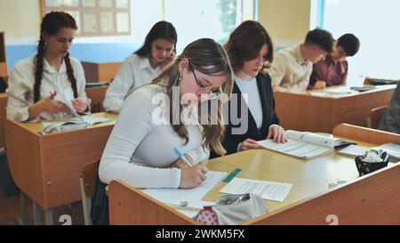 Studentesse che scrivono formule matematiche in un taccuino. Foto Stock