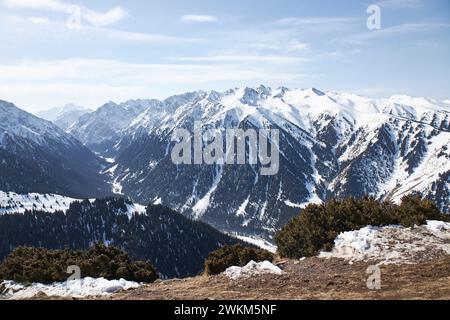 Paesaggio naturale invernale, catena montuosa. Incredibile vista panoramica dalla cima della pista su alte montagne innevate. Karakol Gorge, località sciistica del Kirghizistan Foto Stock