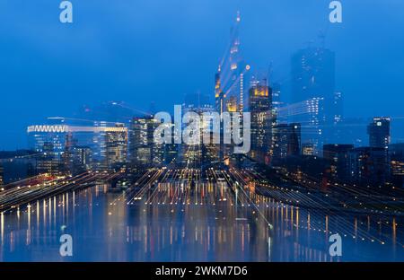 21 febbraio 2024, Assia, Francoforte sul meno: Le luci dello skyline bancario di Francoforte sul meno si illuminano all'ultima luce del giorno (ripresa con effetto zoom) foto: Boris Roessler/dpa Foto Stock