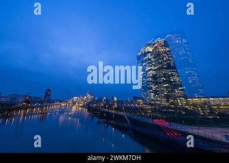 21 febbraio 2024, Assia, Francoforte sul meno: Le luci dello skyline della banca di Francoforte sul meno e della BCE brillano nell'ultima luce della giornata (ripresa con effetto zoom). Foto: Boris Roessler/dpa Foto Stock