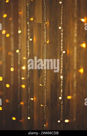 Le luci delle fate sono appese su una recinzione accanto a una porta vecchia su uno sfondo scuro Foto Stock