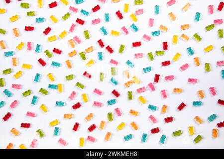 Sfondo colorato con grana di orsi gommosi - delizie dolci su sfondo bianco Foto Stock