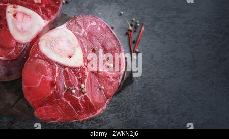 ossobuco. Bistecca di manzo osso buco, ossobuco italiano. Sfondo nero. Vista dall'alto. Copia spazio. Foto Stock