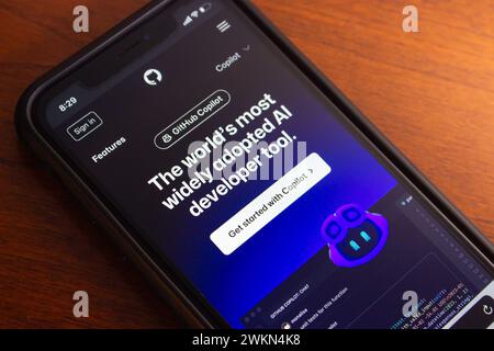 Sito Web GitHub Copilot su iPhone. GitHub Copilot è uno strumento di completamento del codice ai che suggerisce linee di codice o interi funzioni ai programmatori durante la digitazione. Foto Stock