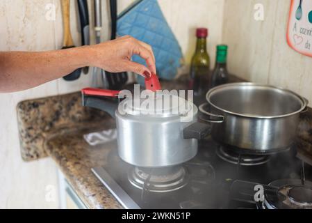 Rimuovere manualmente la pressione dell'aria da una coppa. Cura in cucina. Foto Stock