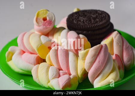 11 maggio 2023, Wonosobo Indonesia: Foto di oreos e marshmallow su un piccolo piatto verde su sfondo bianco. Foto Stock