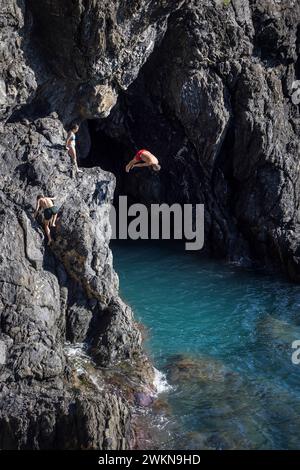 La vita quotidiana a Monterosso, una delle cinque città che compongono le cinque Terre in Liguria, comprende immersioni dalle scogliere nel Mediterraneo. Foto Stock