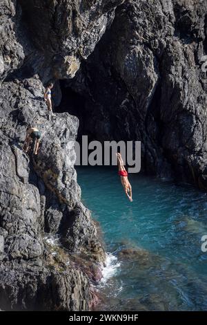 La vita quotidiana a Monterosso, una delle cinque città che compongono le cinque Terre in Liguria, comprende immersioni dalle scogliere nel Mediterraneo. Foto Stock