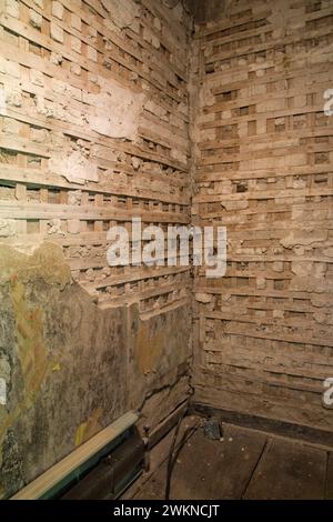 Intonaco parzialmente demolito e pareti in reticolo di legno in camera all'interno di una vecchia casa degli anni '1800. Foto Stock