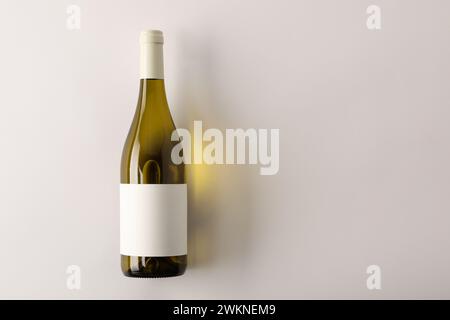 Bottiglia di vino gustoso su sfondo bianco, vista dall'alto. Spazio per il testo Foto Stock