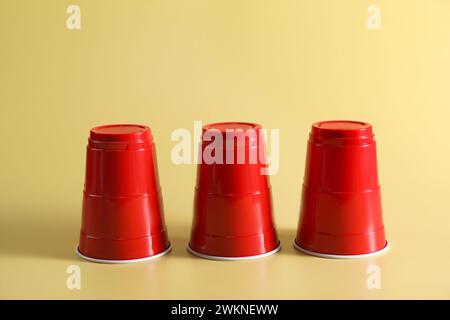 Gioco di shell. Tre tazze rosse su sfondo giallo Foto Stock