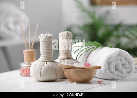 Splendida composizione con diversi prodotti spa su un tavolo bianco su sfondo sfocato Foto Stock