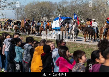 Prairie View, Texas, Stati Uniti. 20 febbraio 2024. I bambini della scuola elementare H.T Jones accolgono la Prairie View Trail Riders Association passando per Waller County, Texas, durante il loro percorso annuale di 67 miglia e di 100 miglia da Hempstead, Texas, a Houston per l'annuale Houston Livestock Show and Rodeo a Houston, Texas, dal 27 febbraio al 17 marzo. La PVTRA è stata fondata nel 1957 e il loro scopo è quello di promuovere l'interesse agricolo nei giovani americani e di perpetuare quei principi e metodi che sono diventati gli ideali e le tradizioni del mondo occidentale e del patrimonio nero occidentale. Foto Stock