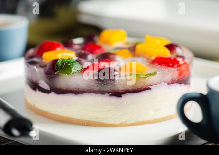 Cheesecake deliziosa e leggera senza cottura con frutta estiva, tra cui fragole, mango e uva. Foto Stock