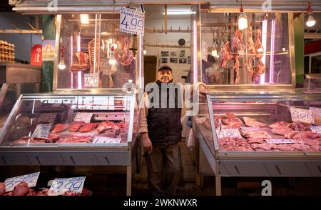 Macellaio, commerciante di carne che si posa orgogliosamente davanti al suo bancone, esposizione di carni fresche, macelleria, cibo, mercato Kapani, Vlali, Salonicco Foto Stock