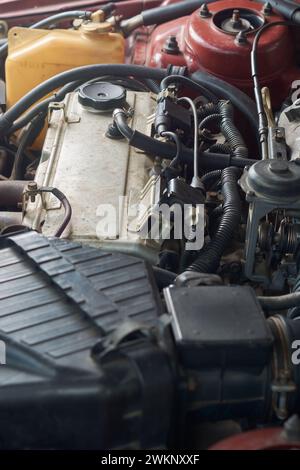 vista laterale del motore o motore di un'auto a quattro cilindri vecchia e usata, motore a benzina a combustione interna ad alte prestazioni in linea retta, attenzione selettiva Foto Stock