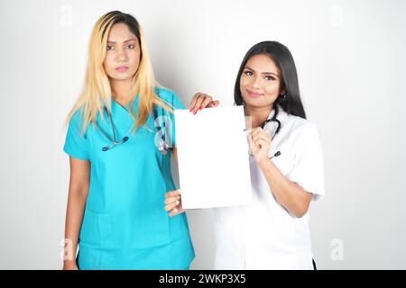 Due donne operatori sanitari in scrub che posa con un segno vuoto Foto Stock