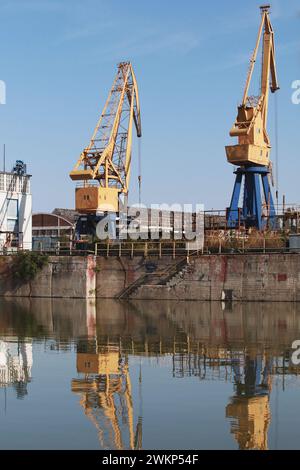Le gru a portale gialle blu si trovano nel porto del carbone di Varna, Bulgaria Foto Stock