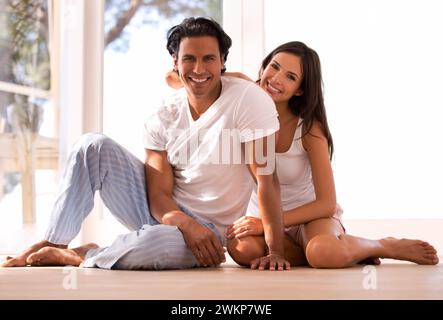 Coppia messicana, ritratti e leganti e sorridenti, al coperto e al tramonto per casa nel soggiorno. Marito, moglie e abbraccio per amore, sicuro di sé e nuovo Foto Stock