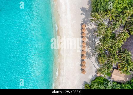 Ville di lusso sull'acqua con palme da cocco, laguna blu, spiaggia di sabbia bianca alle isole Maldive. Vista dall'alto, vacanze estive, paesaggio per le vacanze. Foto Stock