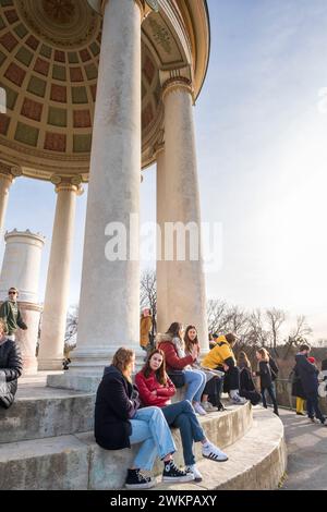 Giovane donna che si gode il sole in una giornata calda alla fine di febbraio ai monopteri dell'Englischer Garten, Monaco, Germania Foto Stock