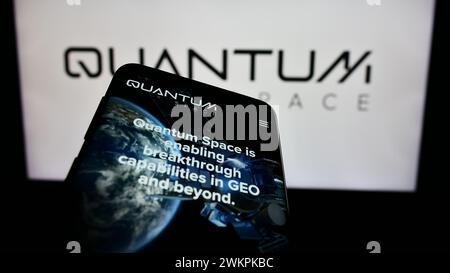 Telefono cellulare con sito web della società aerospaziale statunitense Quantum Space LLC davanti al logo aziendale. Mettere a fuoco in alto a sinistra sul display del telefono. Foto Stock