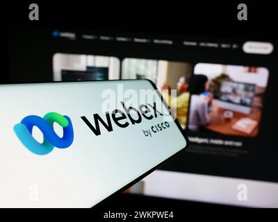 Telefono cellulare con logo della società americana di comunicazioni unificate Webex by Cisco davanti al sito Web aziendale. Messa a fuoco al centro del display del telefono. Foto Stock