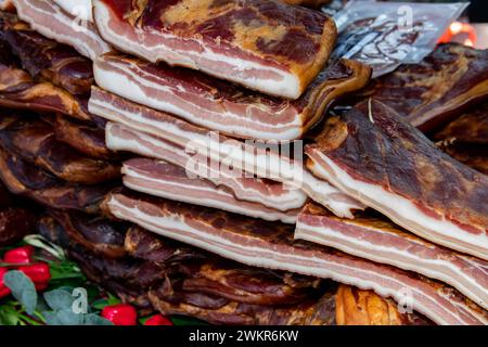 Pancetta esposta e carne secca prodotti domestici presentati per la vendita sul mercato agricolo del villaggio di Kacarevo, bacon gastro e festival dei prodotti a base di carne secca Foto Stock