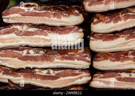Pancetta esposta e carne secca prodotti domestici presentati per la vendita sul mercato agricolo del villaggio di Kacarevo, bacon gastro e festival dei prodotti a base di carne secca Foto Stock