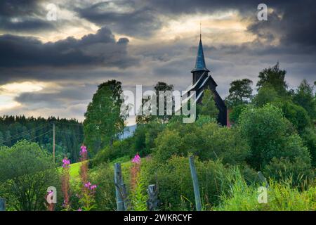 Chiesa di Høre Stave su una collina contro il cielo nuvoloso scuro, Norvegia Foto Stock