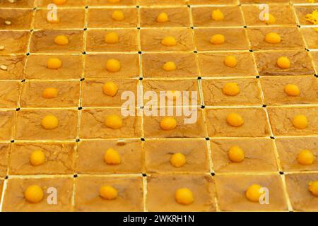 Dessert tailandese uniformemente organizzato, Mo Kaeng, con piccole sfere dorate fatte di tuorli d'uovo e zucchero, disposte su taglio quadrato, che rappresentano l'ar tradizionale Foto Stock