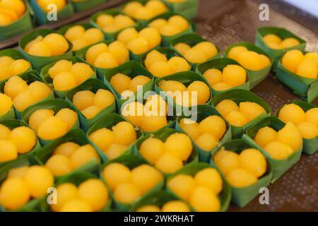 Kanom Thong Yod, un tradizionale dessert tailandese a base di tuorli d'uovo e sciroppo di zucchero, servito in tazze di foglie di banana Foto Stock
