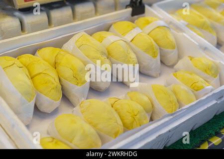 Frutta duriana sbucciata fresca, conosciuta come il "re della frutta", confezionata in pellicola trasparente ed esposta in vendita Foto Stock
