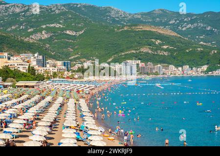 Persone che si rilassano sulla lunga spiaggia di sabbia durante le vacanze estive. Becici, Montenegro Foto Stock