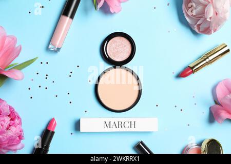Giornata internazionale della donna. 8 marzo in polvere, prodotti per il trucco e bellissimi fiori su sfondo azzurro, piatto Foto Stock