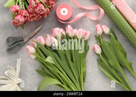 Bellissimi tulipani rosa su un tavolo grigio, piatto Foto Stock