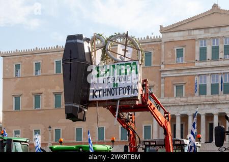 Firmi in greco dicendo "oggi l'allevamento di bestiame è morto”, accanto a una bara nera. E' su un trattore di stanza davanti al Parlamento di Atene, per protestare contro gli agricoltori Foto Stock