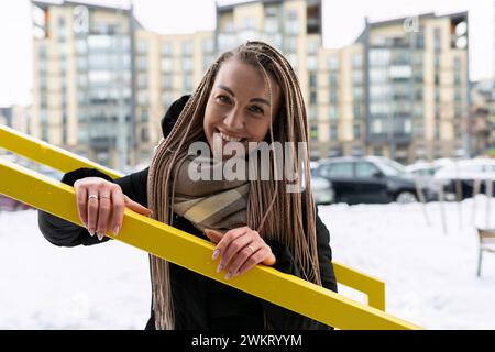 Concetto di stile di vita, giovane e carina donna con dreadlocks acconciatura che sorride dolcemente e si gode una passeggiata Foto Stock