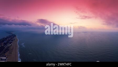 Vista sul mare. Riva del mare durante l'alba. Paesaggio con mare calmo e cielo nuvoloso mattutino luminoso. Vista dall'alto Foto Stock