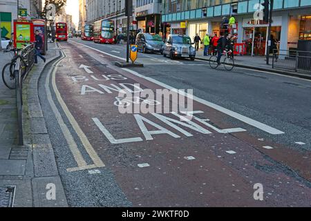 Londra, Regno Unito - 19 novembre 2013: Autobus condiviso con cartello bianco grande e pista ciclabile in Street nel centro della città. Foto Stock