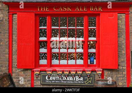 Londra, Regno Unito - 20 novembre 2013: Finestra rossa con decorazioni sulla neve presso l'Anchor Riverside Pub Cask Ale Crafty Cokney Bar Sign presso Thames River Sou Foto Stock