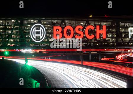 Autobahn A8 Flughafen Stuttgart mit Bosch-Parkhaus. Die 440 metri bietet lange Konstruktion 4200 Fahrzeugen Platz. Bosch HAT Die Namensrechte, der stilisierte Zündanker misst 12 Meter im Durchmesser. Damit ist es eine der größten Leuchtreklamen der Welt. // 04.05.2024: Stoccarda, Baden-Württemberg, Deutschland. *** Superstrada A8 all'aeroporto di Stoccarda con parcheggio a più piani Bosch la struttura lunga 440 metri offre spazio per 4.200 veicoli Bosch ha i diritti di denominazione, l'ancora di accensione stilizzata misura 12 metri di diametro questo la rende una delle più grandi insegne illuminate del mondo Foto Stock