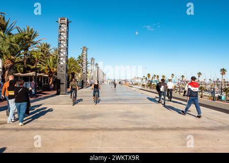 Barcellona, gente di Barceloneta che cammina e cavalca in bicicletta. Pista ciclabile pedonale, lungomare, al tramonto. Foto Stock