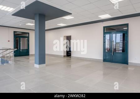 vista panoramica in una moderna sala vuota con colonne, porte, scale e finestre panoramiche. Foto Stock